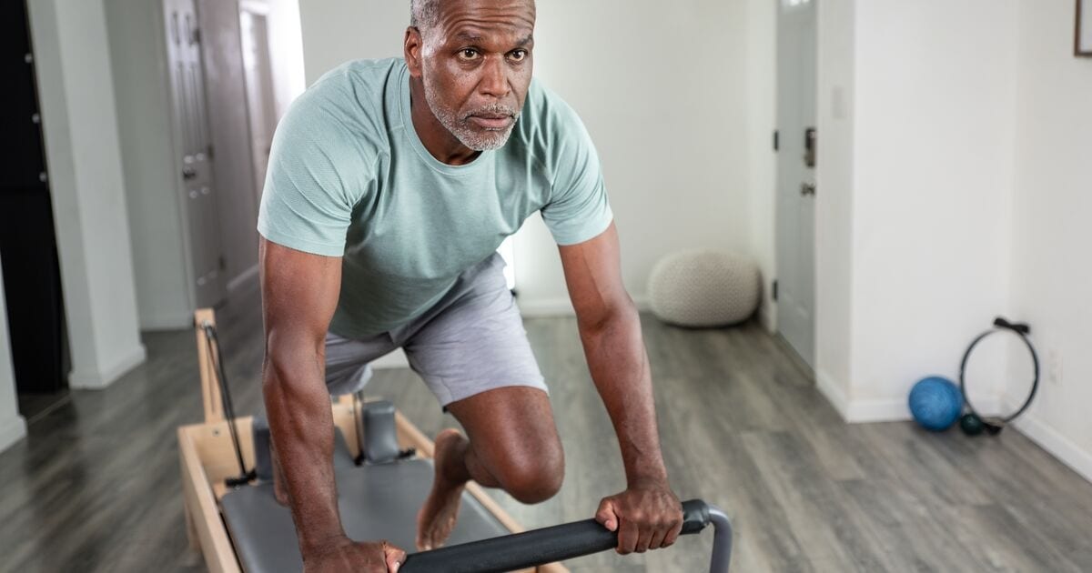 An adult training with focus on a studio Pilates reformer